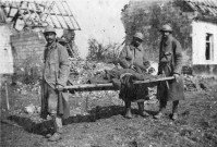 La Grande Guerre dans la Somme. Soldats français portant un brassard avec "X" évacuant un soldat blessé à la tête sur un brancard