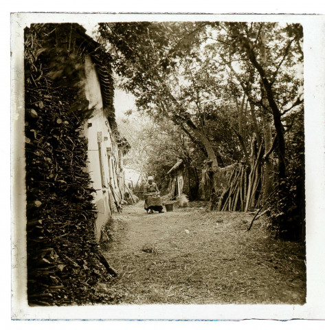 Fontaine-sur-Somme. Une vieille femme assise devant sa maison