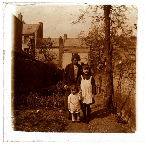 Une femme et deux enfants dans un jardin à Amiens