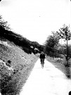 Portrait d'un cycliste sur une route longeant un coteau