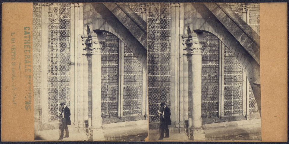 La cathédrale d'Amiens. Un homme prend la pose sous les arcs-boutants de la nef, au niveau des fenêtres hautes