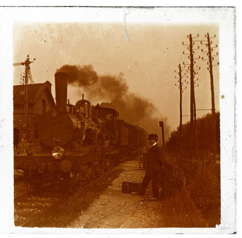 Gare de Blangy-Tronville. Arrivée d'un train à vapeur. Un homme au chapeau melon attend sur le quai de la gare