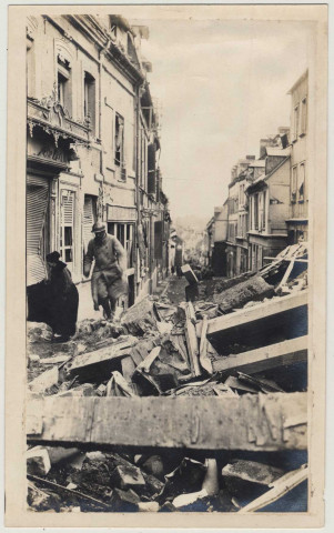 Un soldat enjambe les ruines dans une rue de Roye