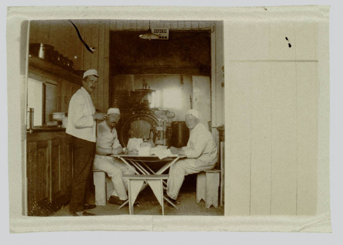 PHOTOGRAPHIE PRISE PAR CLOVIS GUITTET. MONTRANT TROIS INFIRMIERS DANS UN INTERIEUR. GUITTET Clovis (....-1976), préparateur en pharmacie, affecté en 1914 à l'ambulance 5/4 (du 4e corps d'armée). Puis, en 1916, à l'ambulance chirurgicale n° 18, en restant sous les ordres du docteur Launay, qui avait tenu à le garder près de lui