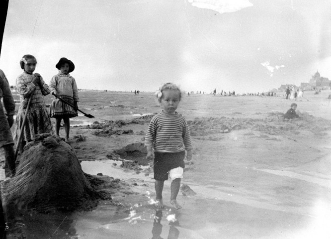 Scène du littoral. Des enfants jouant sur la plage devant les cabines