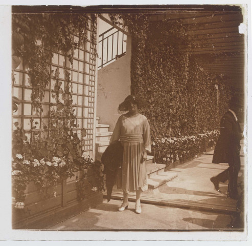 Femme posant près de plantes grimpantes