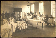 Carte photo d'une salle de l'hôpital militaire d'Issoire, sur laquelle figure Alfred Hennebert (à droite allongé sur le lit n° 2)