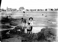 Paysage littoral. Un groupe de touristes et d'enfants sur la plage à marée basse