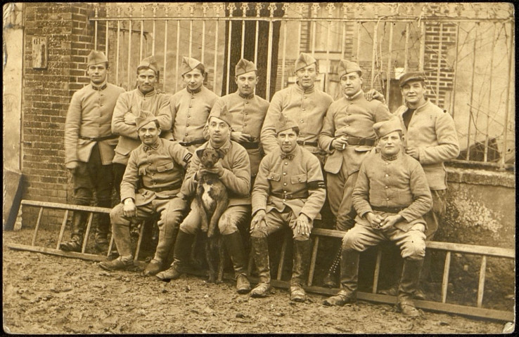 Carte photo représentant onze soldats et un chien
