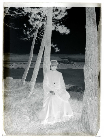 Portrait d'un prêtre assis sous des arbres en bord de mer