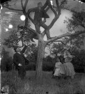 Scène familiale et humoristique. Portrait d'un jeune homme jouant sur les branches d'un arbre