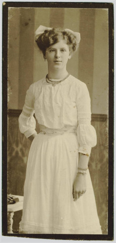 PHOTOGRAPHIE MONTRANT UNE JEUNE FEMME VETUE D'UNE ROBE BLANCHE