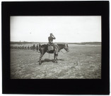[Un exercice de tir durant une campagne de manoeuvres militaires dans la Somme. Un officier à cheval observe avec des jumelles les tirs]