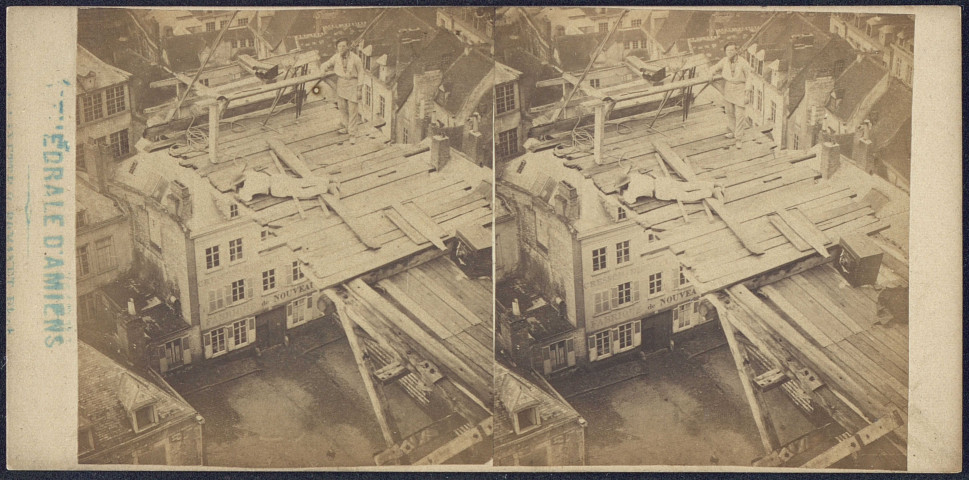 La cathédrale d'Amiens. Deux ouvriers sur la plateforme d'un échafaudage depuis la tour sud vers le flanc sud. Vue plongeante vers les maisons en contrebas