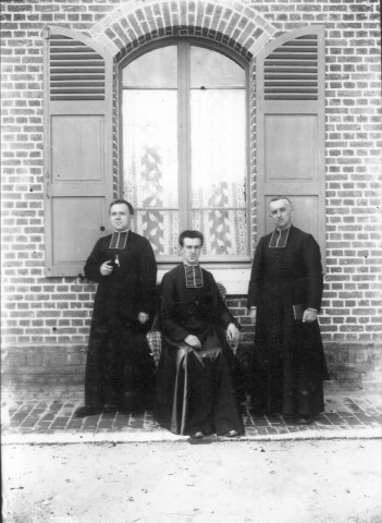Portrait de trois prêtres devant le nouveau presbytère