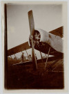 Photographie montrant une vue sur l'avant d'un avion biplan ZODIAC 2S. Silhouette de trois civils à travers les ailes