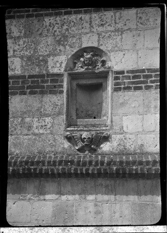Niche sculptée (tête d'ange et tête de mort) sur la façade latérale d'une église