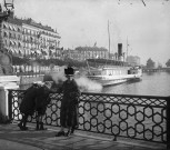 Femme appuyée contre la balustrade d'un pont de la ville de Genève, avec à ses côtés deux jeunes personnes de dos regardant dans l'eau. Bateau à vapeur "SUISSE" accosté et "Le grand hôtel de la Paix" en arrière plan