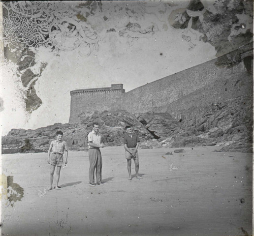 [Trois jeunes gens sur la plage de Saint-Malo devant les remparts et la tour Bidouane. Ce cliché semble postérieur à la mort de F. Poidevin]