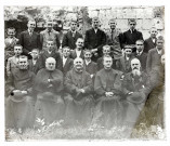 Photo de groupe devant les ruines du château de Folleville : prêtres et jeunes garçons