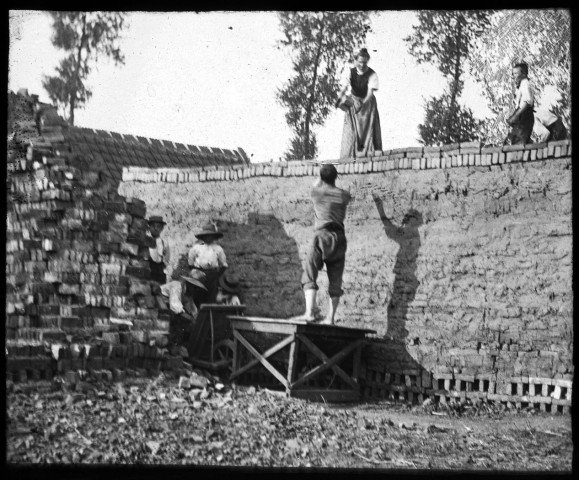 Les briquetiers réalisant une construction de terre et de briques