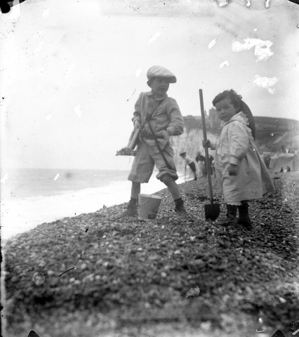 Portrait d'enfants ramassant des galets près de la falaise