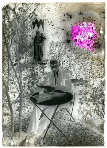 Un homme attablé dans un jardin, lisant la Bible. Au second plan statue de la Vierge et l'Enfant