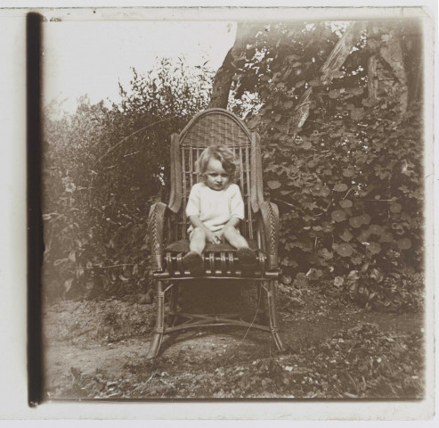 Enfant dans un fauteuil en osier